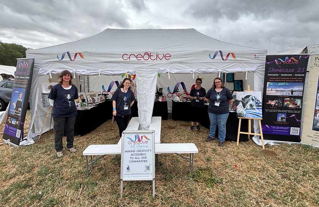 Photo of a Creative Arts Showcase standing by a marque