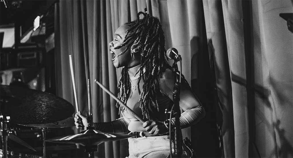 Photo of Romana Cambell playing drums
