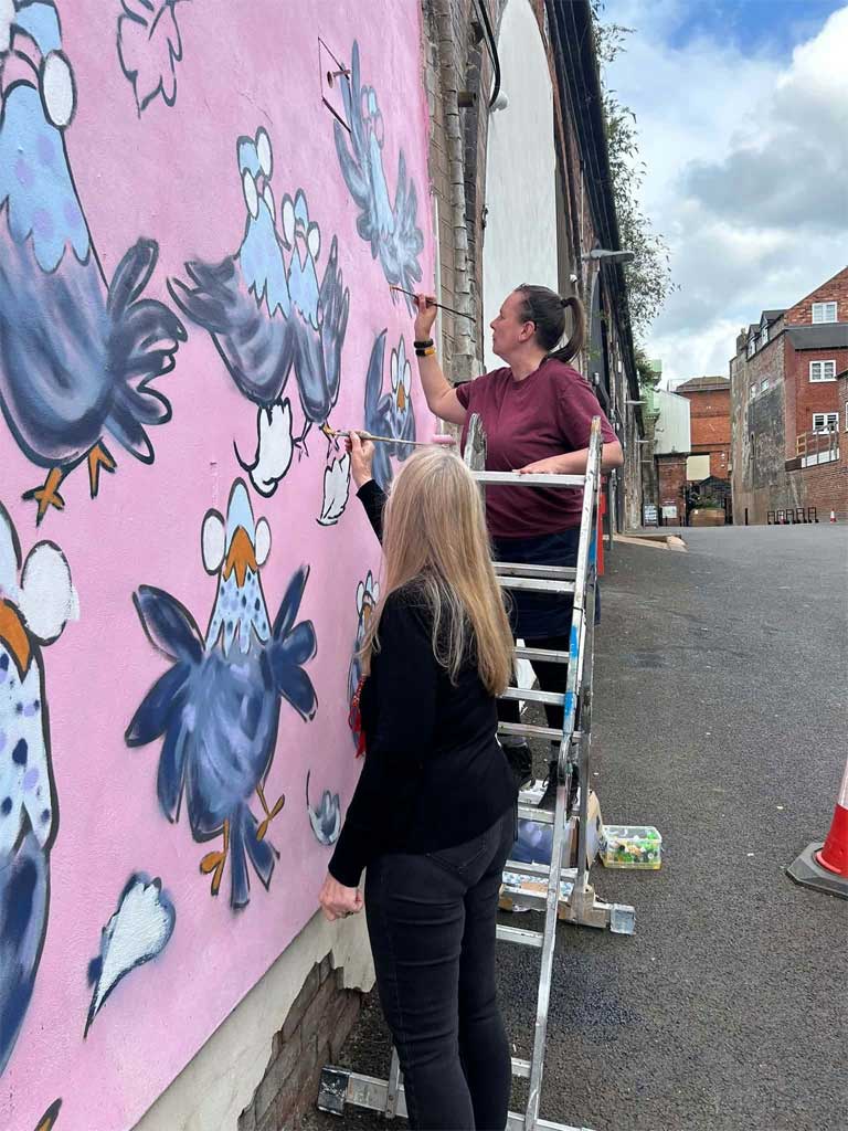 Photo of people painting mural